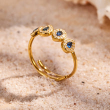 Blue 5A zircon gold ring displayed on sand background for boutique ring and gift jewelry styling