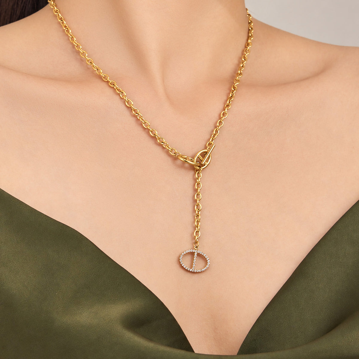 Gold zircon toggle drop necklace with geometric pendant detail worn on model