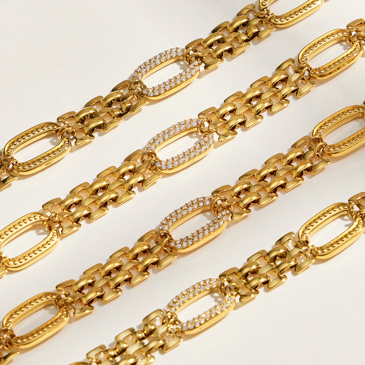 Close-up of stainless steel watch band chain links with zircon-set oval accents